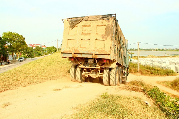 Xe trọng tải lớn chở vật liệu chạy cắt mặt đê mùa mưa bão