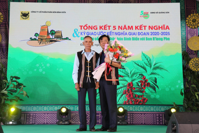 Ông Ngô Văn Đông, Tổng giám đốc Phân bón Bình Điền nhận bó hoa tươi thắm từ đại diện bon R’long Phe (Ảnh:Đình Thế)