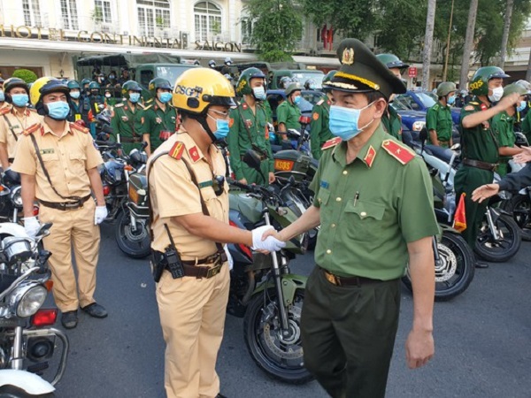 Thiếu tướng Lê Hồng Nam - Giám đốc Công an TPHCM bắt tay khích lệ tinh thần của các chiến sĩ trước giờ ra quân. Ảnh: CHÍ THẠCH