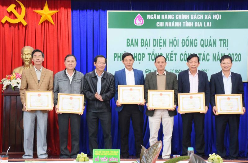 Phó Chủ tịch Thường trực UBND tỉnh, Trưởng ban Đại diện Hội đồng Quản trị Ngân hàng CSXH tỉnh Đỗ Tiến Đông tặng giấy khen cho các tập thể có thành tích trong công tác phối hợp. Ảnh: Minh Nguyễn