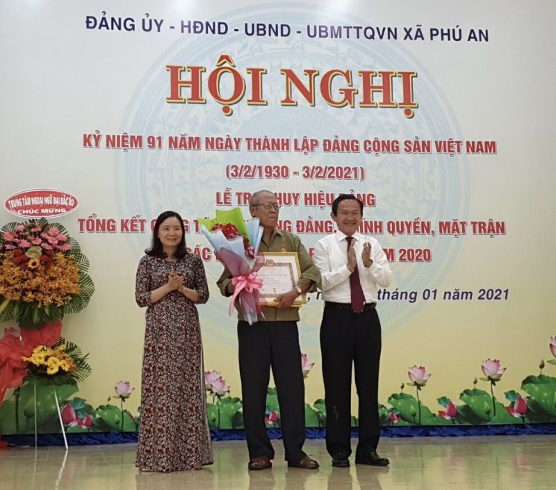 Ông Nguyễn Hoàng Thông, Phó Bí thư Thường trực Thị ủy Bến Cát và lãnh đạo địa phương trao Huy hiệu 55 tuổi Đảng cho 1 đảng viên. Ảnh: Thoại Phương