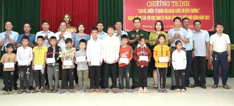 Lãnh đạo huyện và Ban CHQS huyện trao quyết định và kinh phí hỗ trợ nhận nuôi cho các em học sinh người dân tộc thiểu số có hoàn cảnh đặc biệt khó khăn.