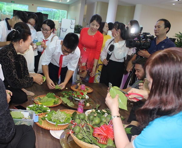 Các em học sinh và người dân được nghệ nhân hướng dẫn cách têm trầu cánh phượng