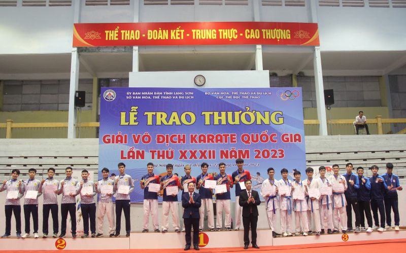 Ban Tổ chức trao huy chương cho các vận động viên xuất sắc nội dung Kumite đồng đội nam, nhóm 1