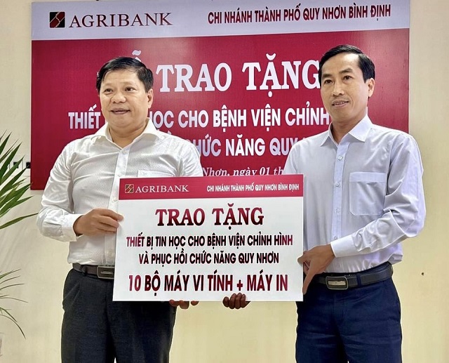 Ông Trần Hồng Nghiễm (bên phải) trao bảng tài trợ cho lãnh đạo Bệnh viện Chỉnh hình và Phục hồi chức năng Quy Nhơn. Ảnh: V Nam.