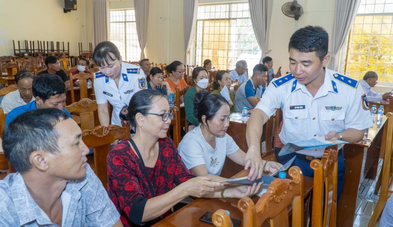 Cảnh sát biển phát tờ rơi và tuyên truyền đến ngư dân Luật Cảnh sát biển, tuyên truyền chống khai thác hải sản bất hợp pháp, không khai báo và không theo quy định.