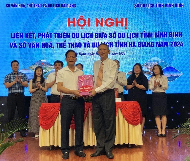 Ông Trần Văn Thanh (hàng đầu, bên phải) tặng quà lãnh đạo Sở VH-TT&DL Hà Giang. Ảnh: V.H