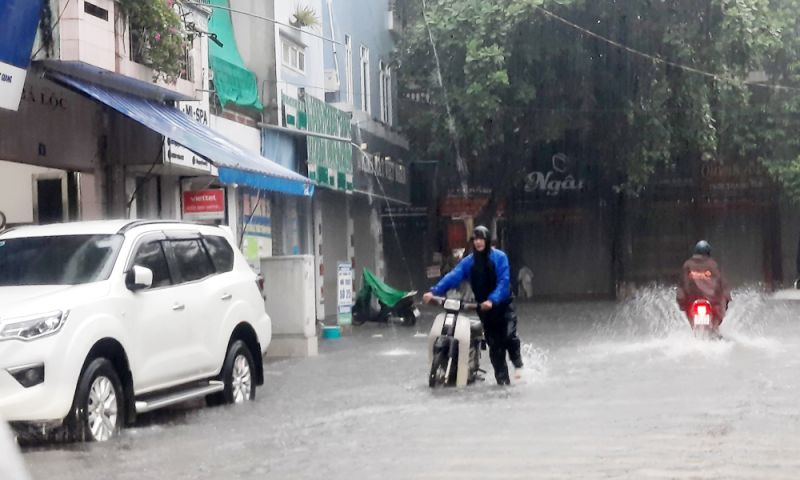 Mực nước dâng cao khiến một số phương tiện bị chết máy, người dân phải dắt bộ xe