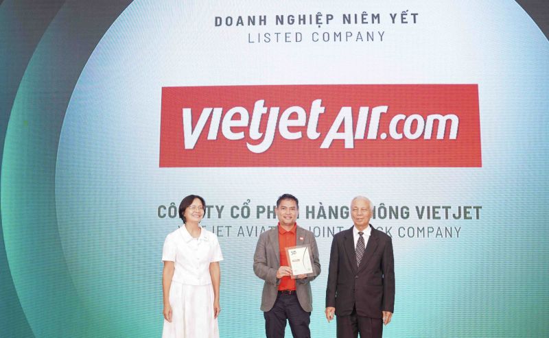 Ông Nguyễn An Di - Giám đốc Nhân sự Vietjet (áo T - shirt đỏ, áo khoác ghi xám) nhận giải thưởng tôn vinh Top 50 doanh nghiệp phát triển bền vững từ ban tổ chức