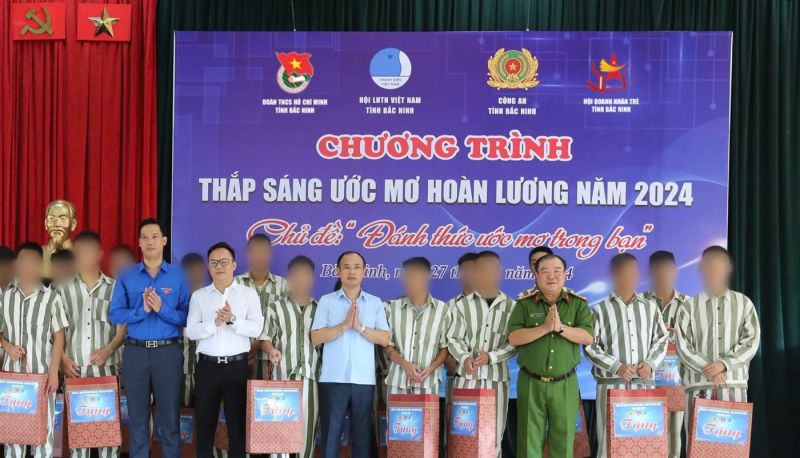 Các đồng chí lãnh đạo trao quà cho phạm nhân thanh niên cải tạo tốt.