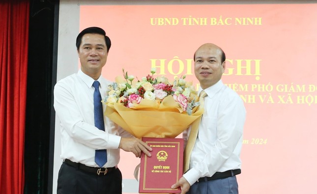 Phó Chủ tịch UBND tỉnh Bắc Ninh Lê Xuân Lợi (bên trái) tặng hoa chúc mừng ông Trần Ngọc Đạo.