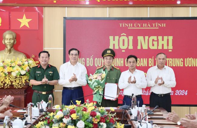 Các đồng chí trong Ban Thường vụ Tỉnh ủy trao quyết định và tặng hoa chúc mừng Đại tá Nguyễn Xuân Thao.