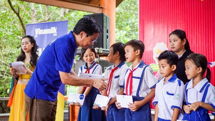 Ông Lê Hoàng Minh, Giám đốc Điều hành sản xuất Vinamilk, trao học bổng cho học sinh khó khăn tại xã Đất Mũi, tỉnh Cà Mau nhân dịp trung thu