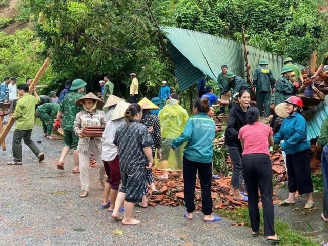 Chính quyền địa phương cùng người dân hỗ trợ gia đình bị ảnh hưởng do sạt lở đất.