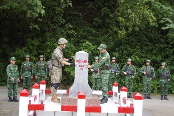 Bộ Chỉ huy tuần tra của BĐBP Lào Cai và Chi đội quản lý biên giới Hồng Hà tặng hoa tại vạch phân định đường biên giới cửa khẩu quốc tế Lào Cai - Hà Khẩu