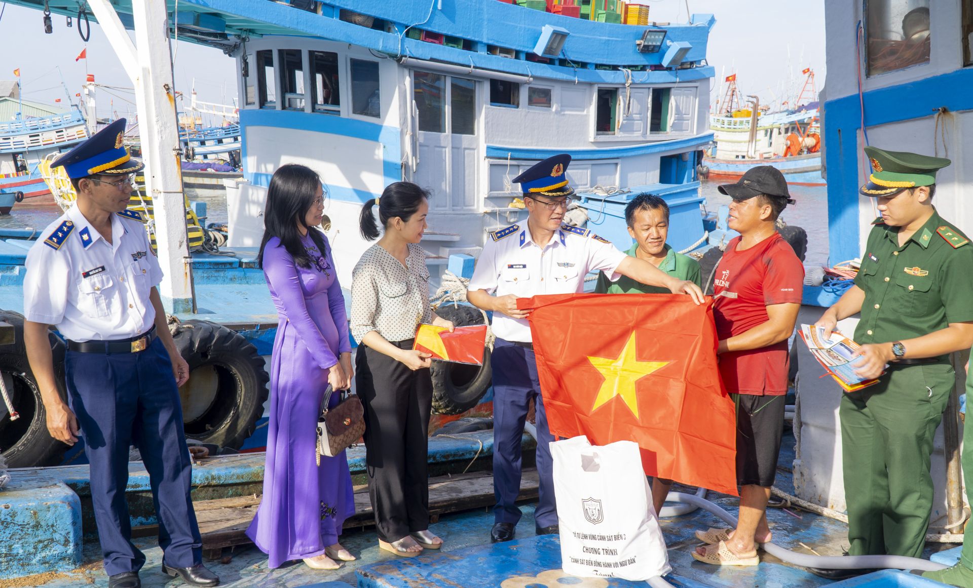 Đại tá Cao Xuân Quận, Phó Chính ủy BTLVùng CSB 3 cùng đại diện cấp ủy, chính quyền địa phương tặng cờ Tổ quốc và tuyên truyền về biển, đảo cho ngư dân Vũng Tàu.