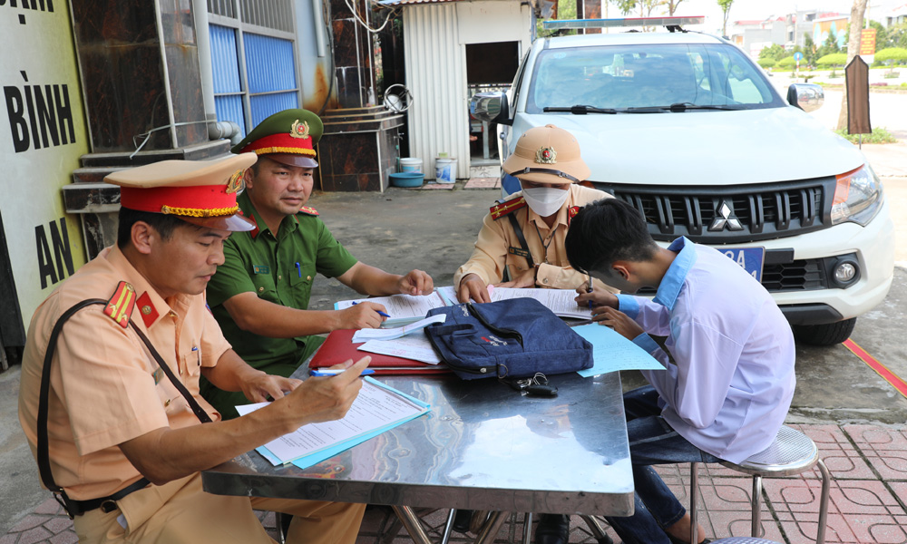 Công an huyện Yên Dũng lập biên bản xử lý một học sinh chưa đủ điều kiện điều khiển xe máy điện.