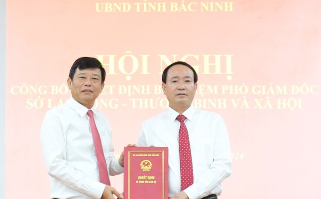 Phó Chủ tịch UBND tỉnh Bắc Ninh Ngô Tân Phượng (bên trái) trao quyết định cho ông Nguyễn Văn Định.