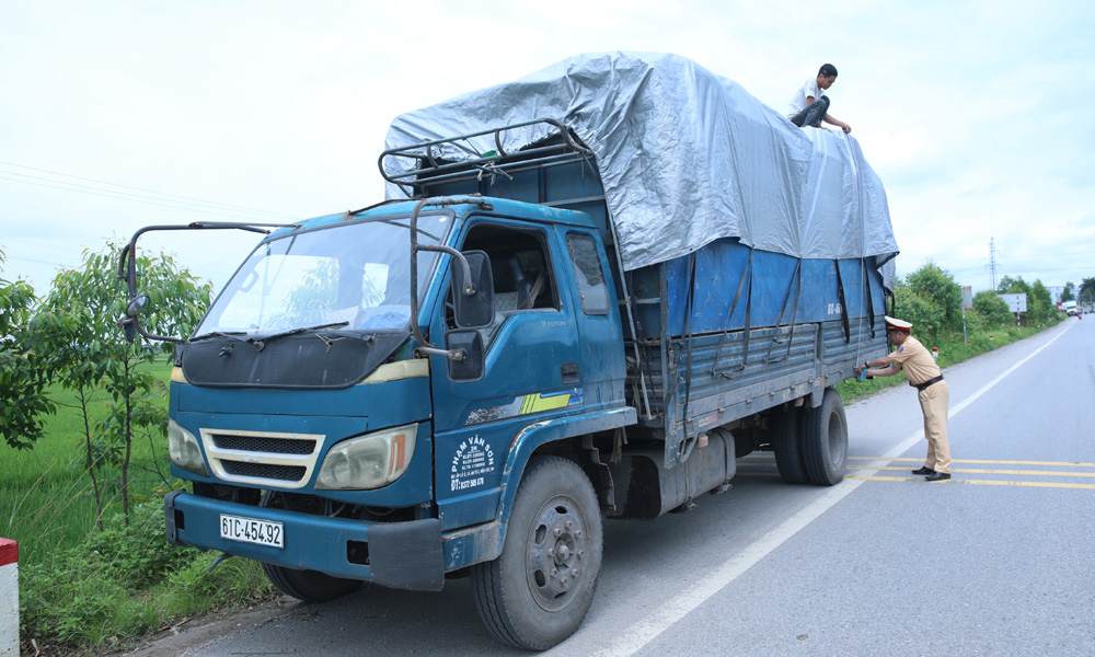 Cảnh sát giao thông Công an huyện Lạng Giang kiểm tra phương tiện chở hàng cồng kềnh, quá khổ trên đường tỉnh 292 đoạn qua xã Nghĩa Hưng.