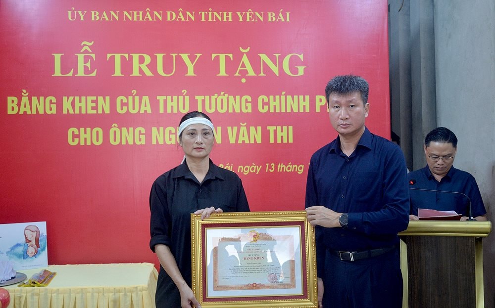 Ông Trần Huy Tuấn, Chủ tịch UBND tỉnh Yên Bái đã trao bằng khen của Thủ tướng Chính phủ cho đại diện gia đình ông Nguyễn Văn Thi. Ảnh: Thanh Ngà