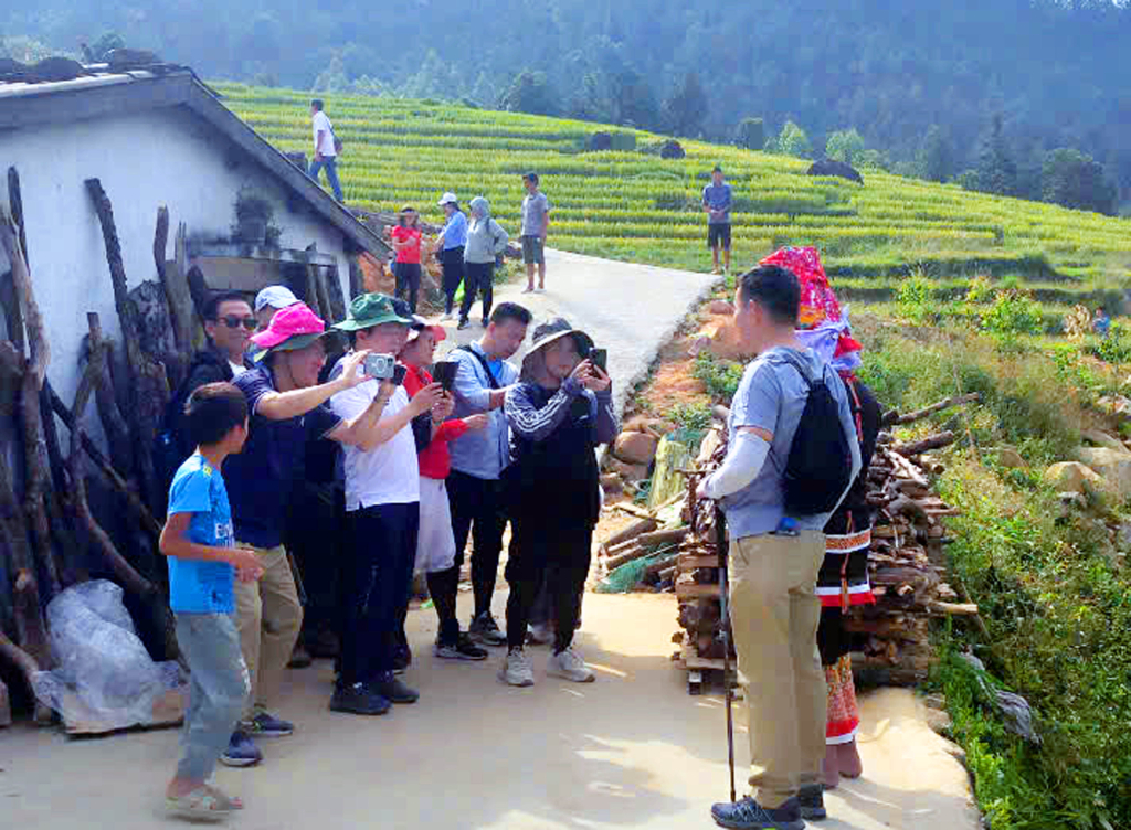 Đại diện các doanh nghiệp tham quan nhà truyền thống, chụp ảnh lưu niệm với đồng bào dân tộc bản sông Moóc (xã Đồng Văn).