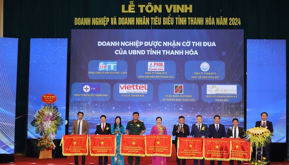 Các đồng chí Ủy viên Ban Thường vụ Tỉnh ủy: Phạm Thị Thanh Thủy, Trưởng Ban Dân vận Tỉnh ủy, Chủ tịch Ủy ban MTTQ tỉnh; Nguyễn Văn Thi, Phó Chủ tịch Thường trực UBND tỉnh trao Cờ thi đua của UBND tỉnh cho Hiệp hội Doanh nhân nữ tỉnh Thanh Hoá và 6 DN.