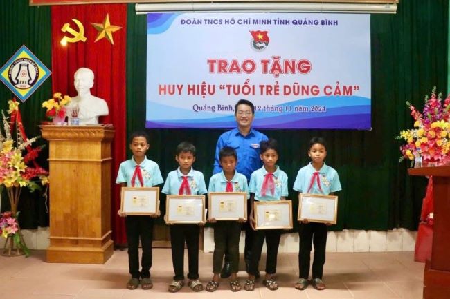 Phó Bí thư Tỉnh Đoàn, Chủ tịch Hội đồng Đội tỉnh Quảng Bình Đinh Trung Hiếu trao tặng Huy hiệu tuổi trẻ dũng cảm cho 5 đội viên.