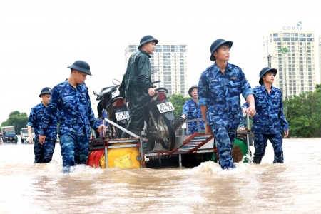 Cảnh sát biển hỗ trợ người dân di chuyển qua vùng ngập sâu khu vực cầu Ngà