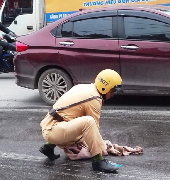 Thanh Hóa: CSGT lau vết dầu nhớt lai láng giữa đường tránh để phương tiện qua lại trượt ngã - Hình 1