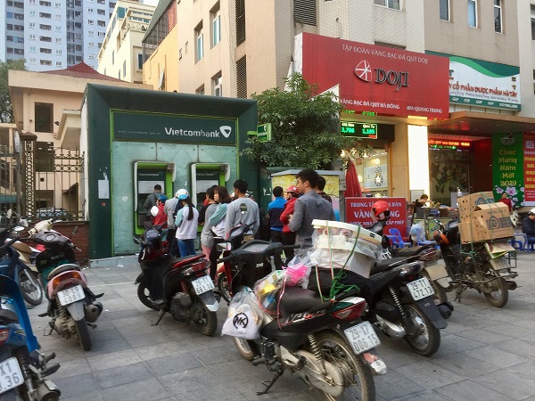 Hà Nội: Người dân xếp hàng dài chờ rút tiền từ cây ATM để về quê ăn Tết - Hình 1