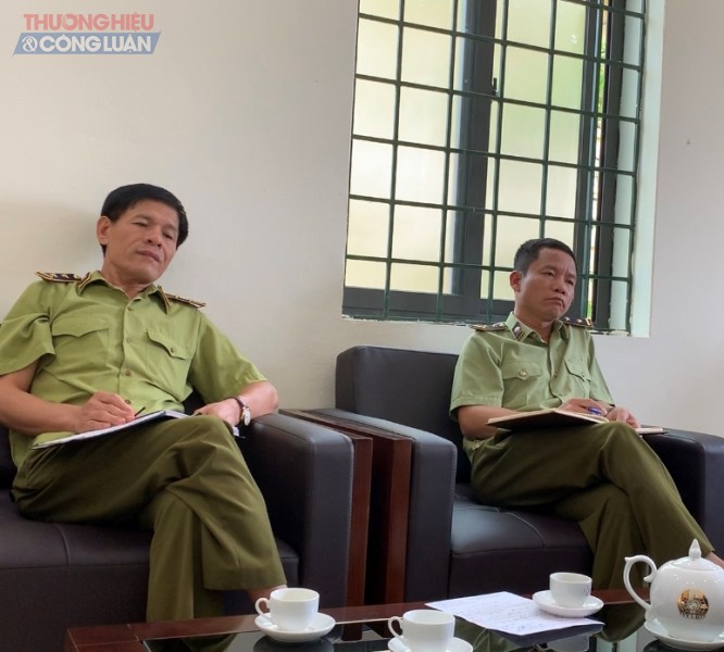 Ông Ngô Anh Hiếu, đội trưởng (bên phải) và ông Nguyễn Cao Hiến, đội phó (bên trái), Đội QLTT số 20 trao đổi với PV