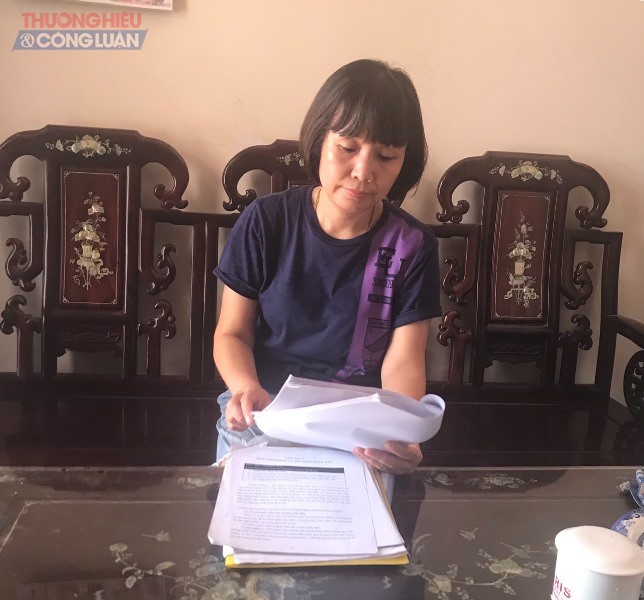 Chị Đinh Thị Vân trao đổi với PV và cung cấp giấy tờ liên quan
