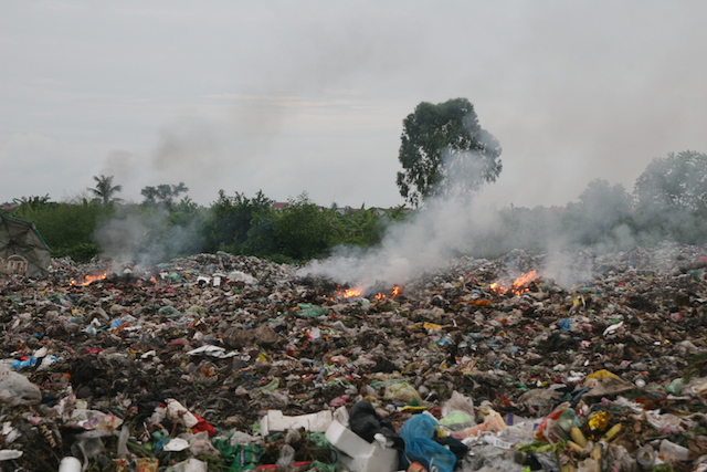 Bãi rác lộ thiên được đốt phía ngoài lò đốt toả mùi hôi thối và két của nhựa vào các khu dân cư