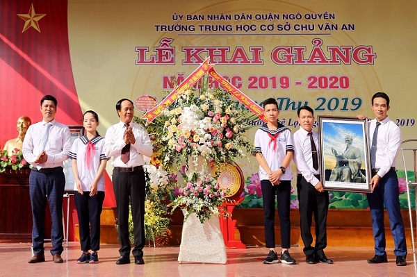 Đồng chí Lê Văn Thành tặng hoa và bức tranh cụ Chu Văn An cho học sinh, giáo viên trường THCS Chu Văn An.