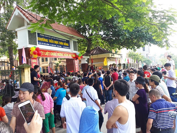 Phụ huynh học sinh tập trung tại cổng tường Tiểu học Sơn Đồng (huyện Hoài Đức - Hà Nội) phản đối chuyện lạm thu.