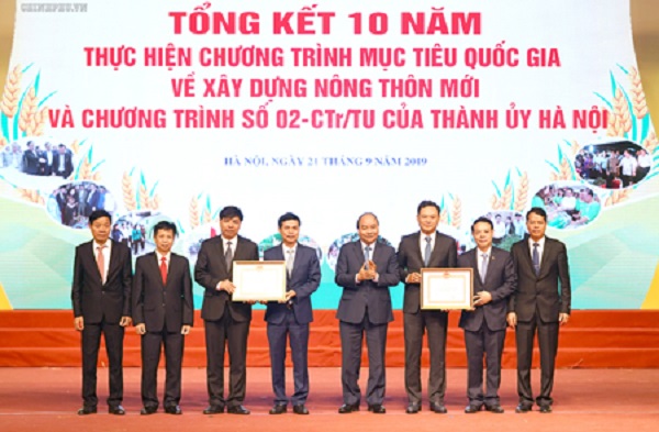 Thủ tướng trao “Bằng chứng nhận đạt chuẩn nông thôn mới” cho huyện Gia Lâm, huyện Quốc Oai (Ảnh: VGP/Quang Hiếu)