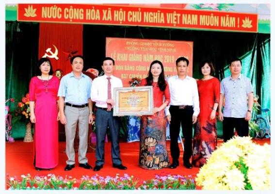 Ông Đàm Hữu Khanh - Phó Chủ tịch TT HĐND huyện VinhTường (đứng thứ ba từ trái sang) trao bằng công nhận trường đat chuẩn quốc gia mức độ 2