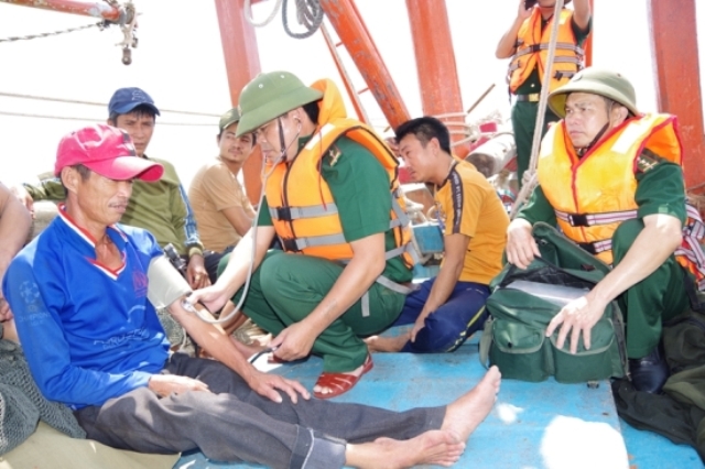 Cán bộ quân y BĐBP Quảng Bình tiếp cận và kiểm tra sức khỏe cho các thuyền viên tàu bị nạn