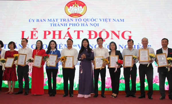 Chủ tịch Ủy ban MTTQ Việt Nam TP. Hà Nội Nguyễn Lan Hương trao giấy chứng nhận ủng hộ Quỹ Vì người nghèo (Ảnh:NK)