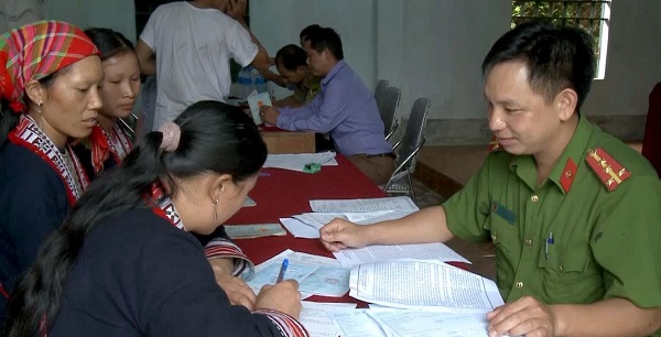 Công an phụ trách xã Phàn Dào Quyên đang hướng dẫn thu thập thông tin dân cư bằng tiếng Dân tộc cho bà con tại xã Nậm Ty (huyện Hoàng Su Phì, Hà Giang)