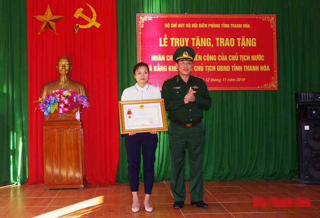 Chị Lương Thị Chon, vợ thiếu tá Vi Văn Nhất nhận huân chương