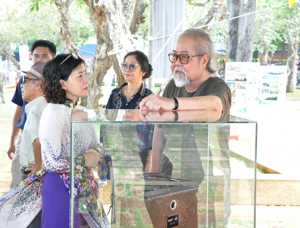 Họa sĩ thiết kế Phạm Quang Vĩnh (phải) tham quan triển lãm. Ông ngạc nhiên khi không thấy hình ảnh phim 