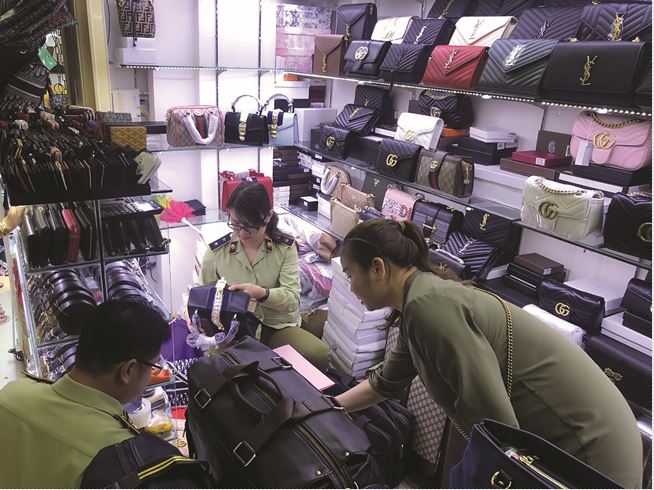 Lực lượng chức năng kiểm tra hàng hóa tại cửa hàng túi xách