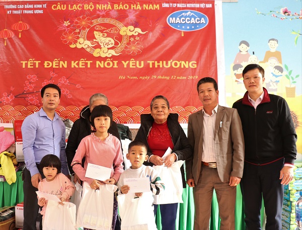 Ông Trần Thanh Tùng – Phó Tổng giám đốc Công ty Cổ phần Macca Nutrition Việt Nam (thứ 2 bên phải) trao quà cho các em nhỏ và người nhà neo đơn tại trung tâm