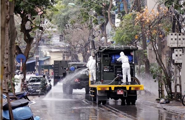 Lực lượng bộ đội hóa học phun hóa chất tiêu tẩy khu vực phố Trúc Bạch, quận Ba Đình (Ảnh: Dương Giang/TTXVN)