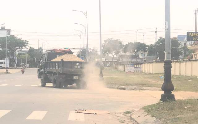 Xe chở c&aacute;t ra khỏi b&atilde;i kh&ocirc;ng che phủ bạt ngang nhi&ecirc;n chạy tr&ecirc;n đường, k&eacute;o theo bụi bặm m&ugrave; trời.