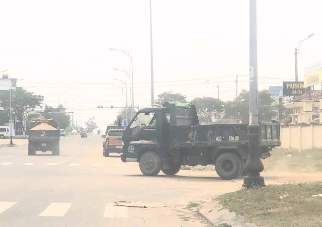 Xe chở c&aacute;t ra khỏi b&atilde;i kh&ocirc;ng che phủ bạt ngang nhi&ecirc;n chạy tr&ecirc;n đường, k&eacute;o theo bụi bặm m&ugrave; trời