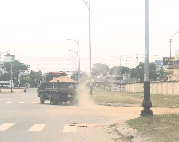 Xe chở c&aacute;t ra khỏi b&atilde;i kh&ocirc;ng che phủ bạt ngang nhi&ecirc;n chạy tr&ecirc;n đường, k&eacute;o theo bụi bặm m&ugrave; trời.