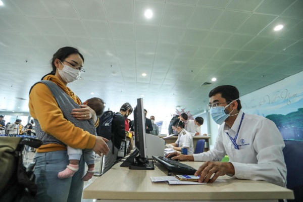 Cán bộ y tế làm công tác khai báo y tế cho hành khách từ nước ngoài về Việt Nam tại sân bay Nội Bài (Ảnh: NGUYỄN KHÁNH)