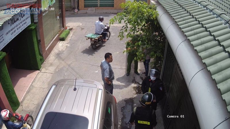 Nhóm 5 cán bộ Công an huyện Trảng Bom và Công an phường Tân Phong xuống đứng tấn trước cửa, đòi bắt ông Hoàng (Ảnh: Camera an ninh ghi lại)